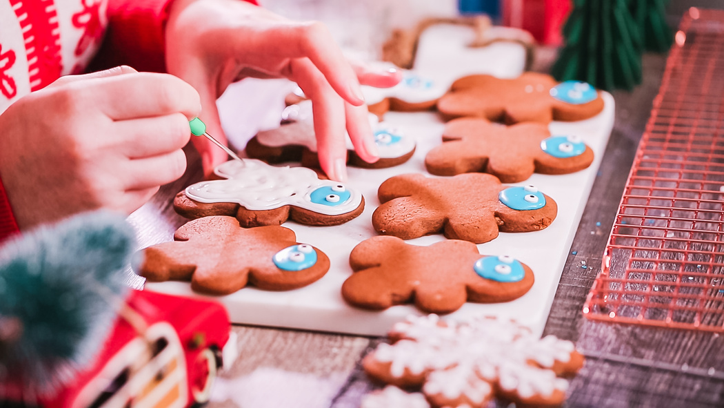 Decorating gingerbread cookies with royal icing.